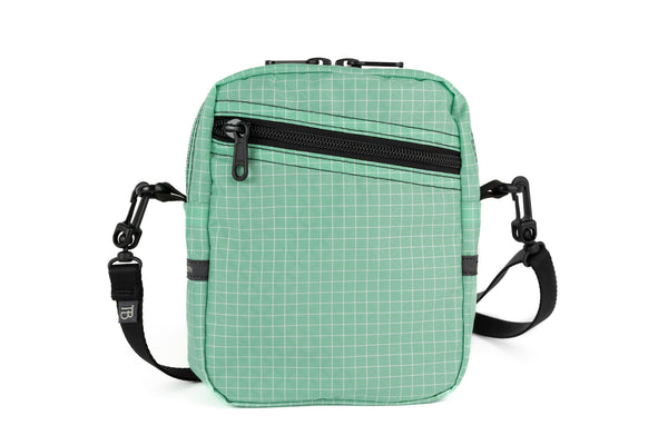An Everyday Cubelet in Seafoam Halcyon (green with a white grid) with a front zipper.